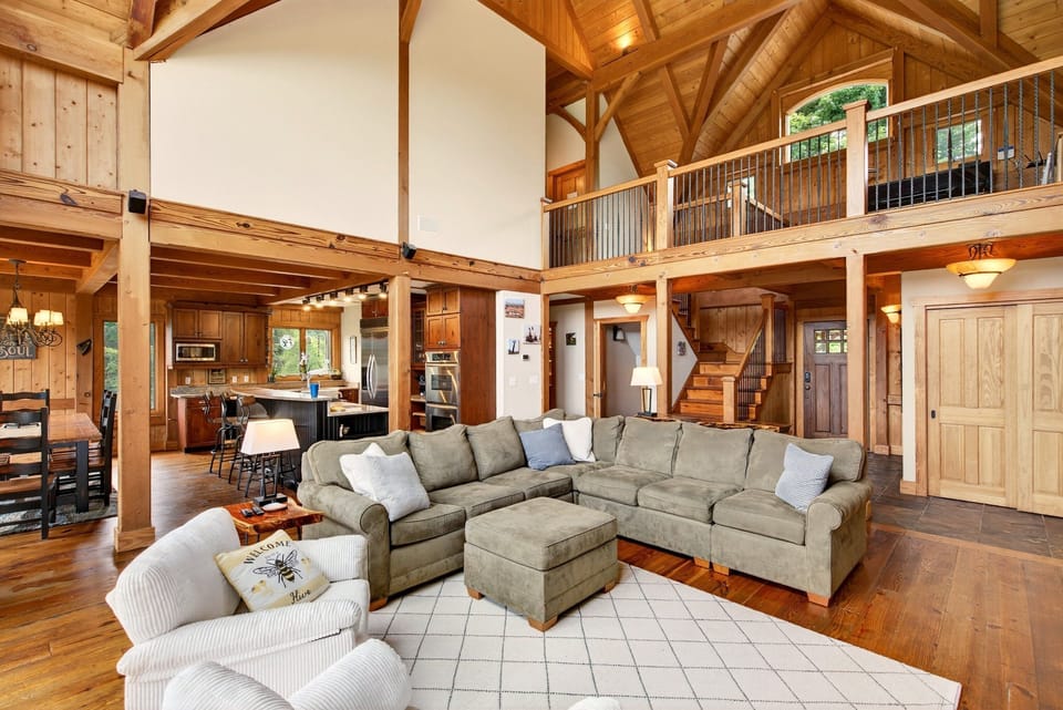 Living room with spacious sectional, TV for streaming, wood stove, and access to the deck