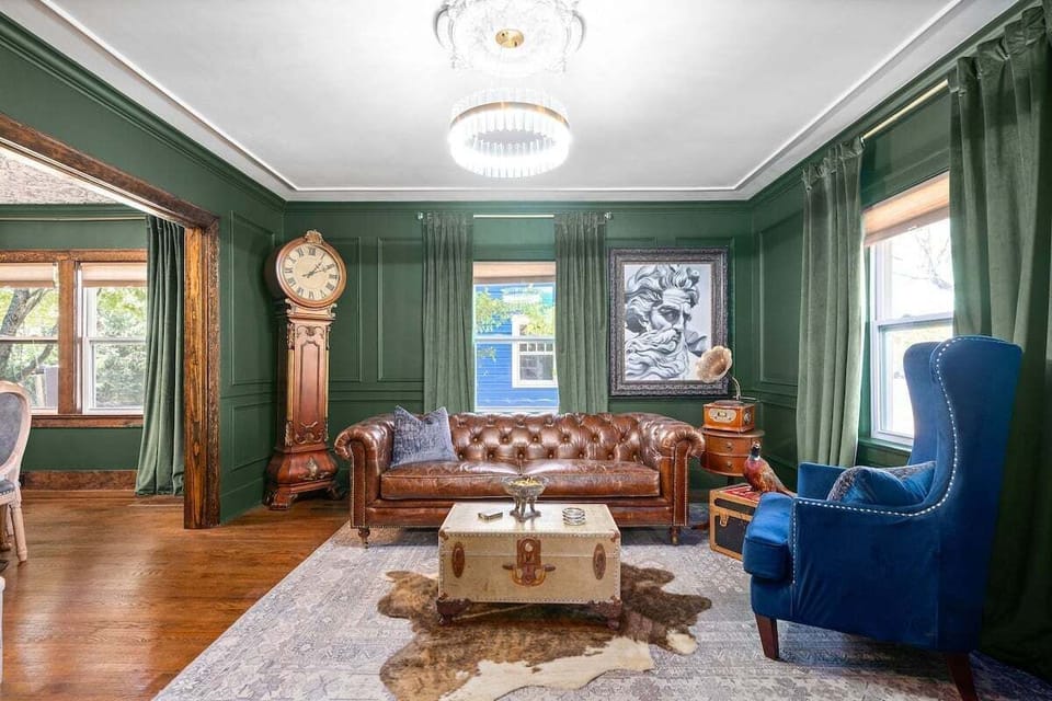 Living room has a local artist oil painting of ZEUS, a blue-tooth phonograph.