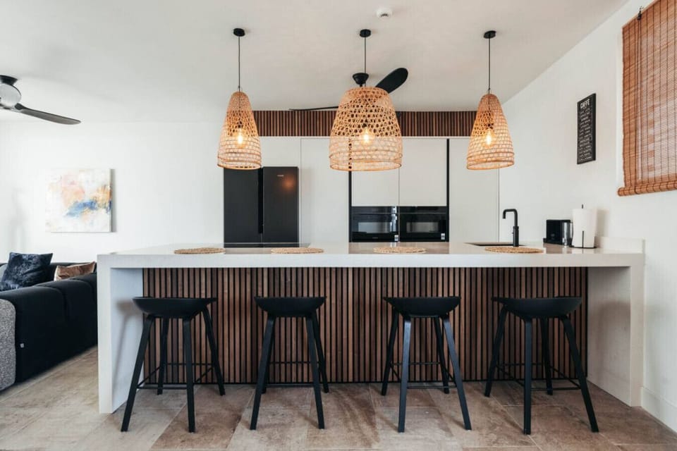 Delight in this modern kitchen featuring chic design and cozy seating, ideal for culinary adventures and memorable gatherings.