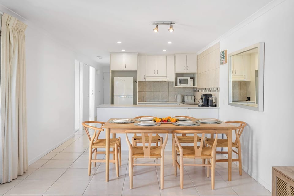 Linger over meals at the wooden dining table, with the modern kitchen close by for effortless hosting.