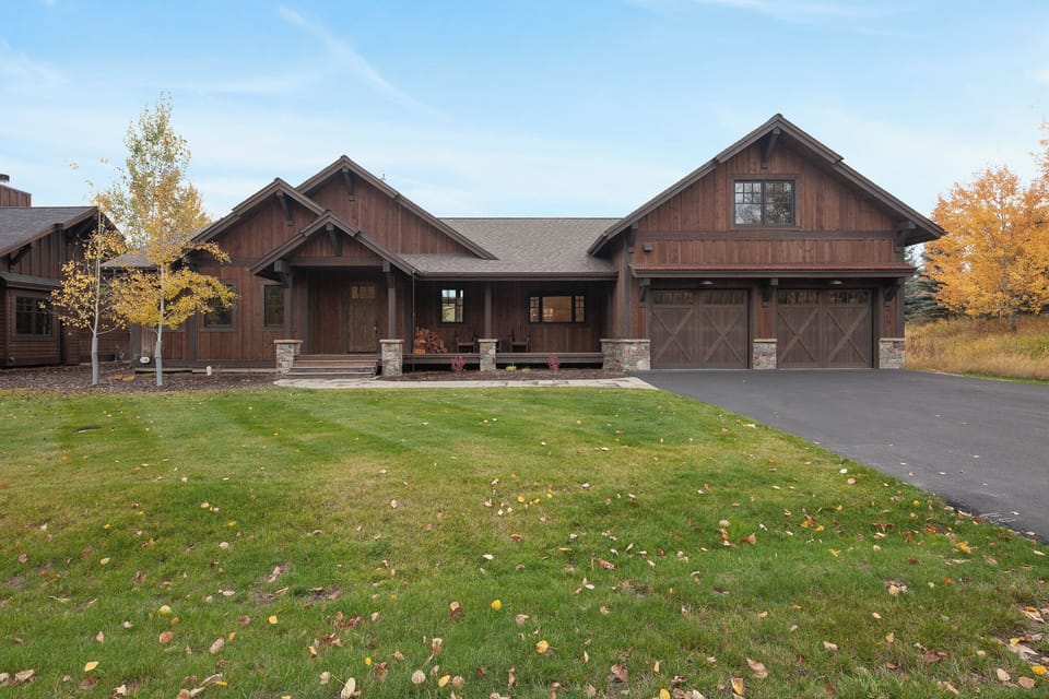 Arrive to a private lodge-style home framed by open lawn.