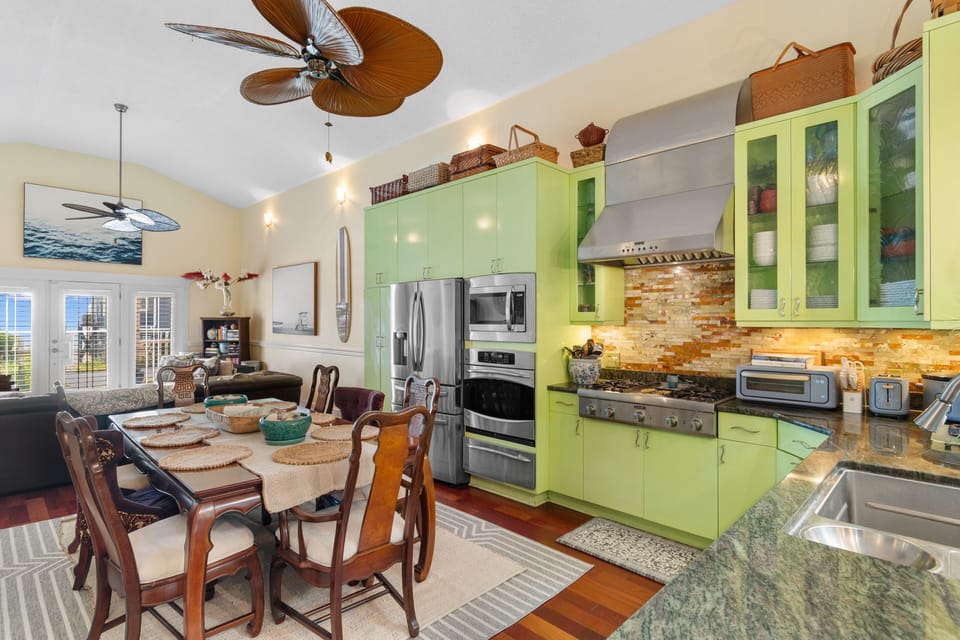Your tropical-inspired kitchen beckons with vibrant lime cabinets, granite counters, and full appliances perfect for creating memorable meals together.