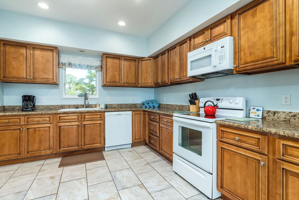 Your spacious kitchen features rich wood cabinetry, granite countertops, and modern appliances perfect for preparing memorable meals.