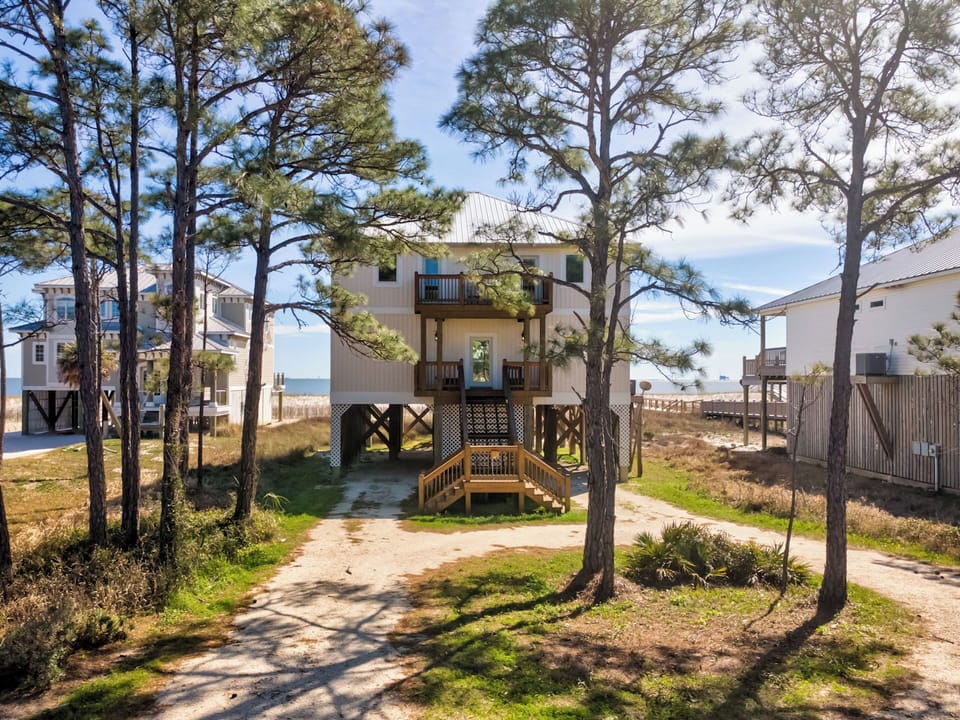This elevated beach house sits nestled among pines in a peaceful coastal neighborhood.