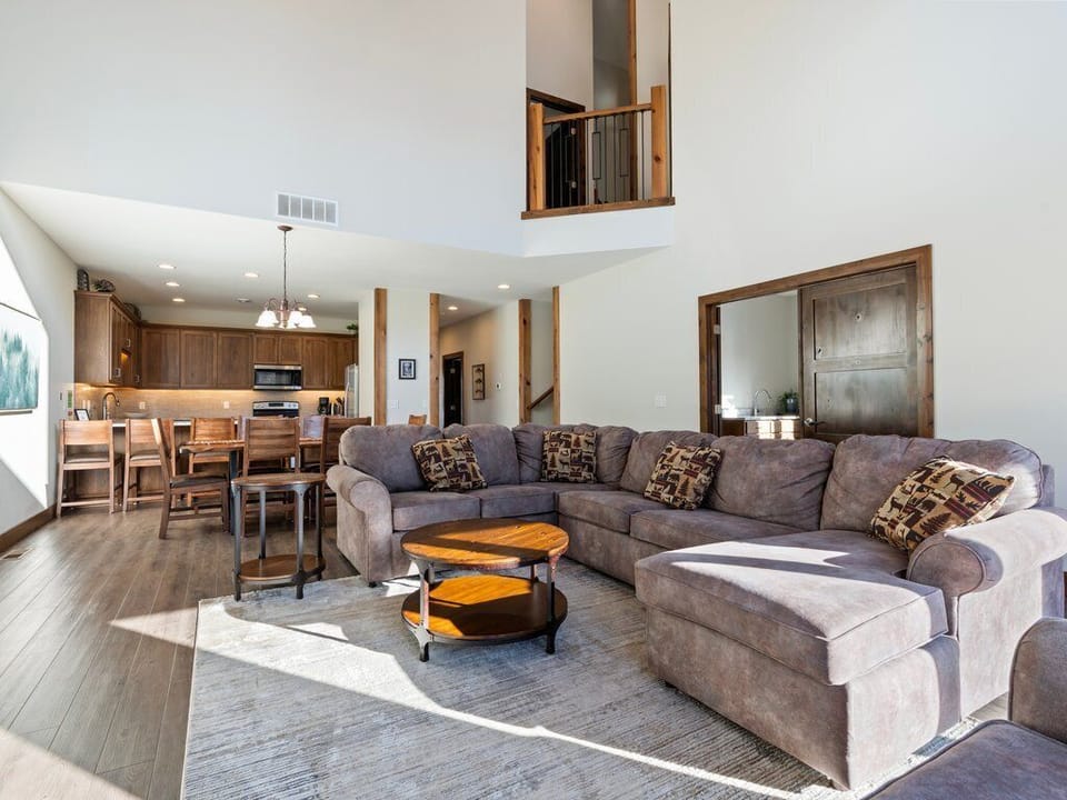 Unwind in your spacious open-concept living area, where soaring ceilings and warm wood accents create the perfect mountain retreat atmosphere.