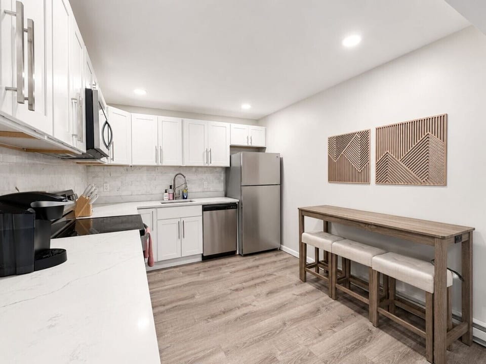 Fully equipped kitchen with stainless-steel appliances and dining area.