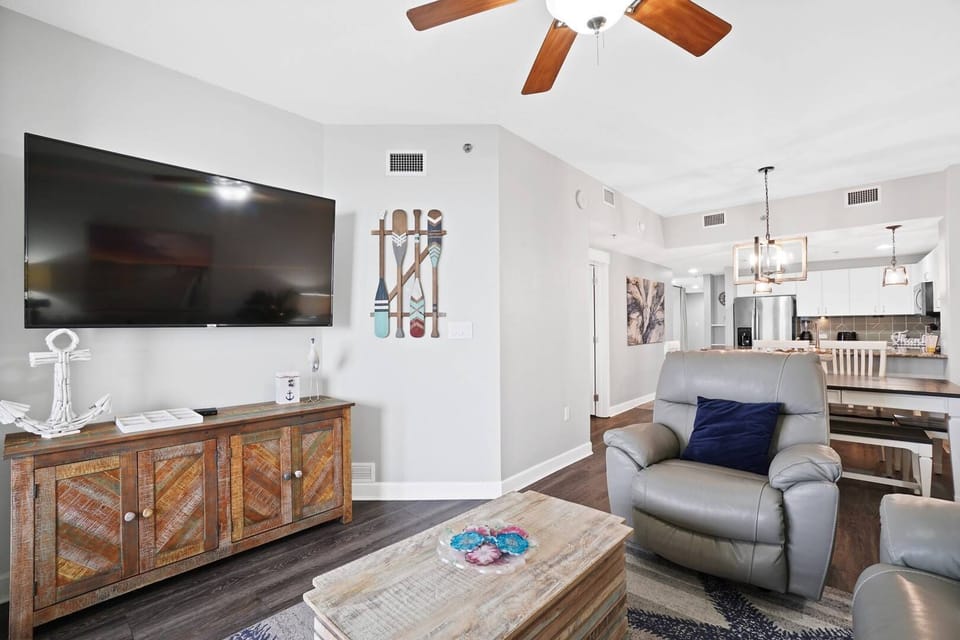 Unwind in your stylish living space with plush recliners, large TV, and open kitchen for easy entertaining.