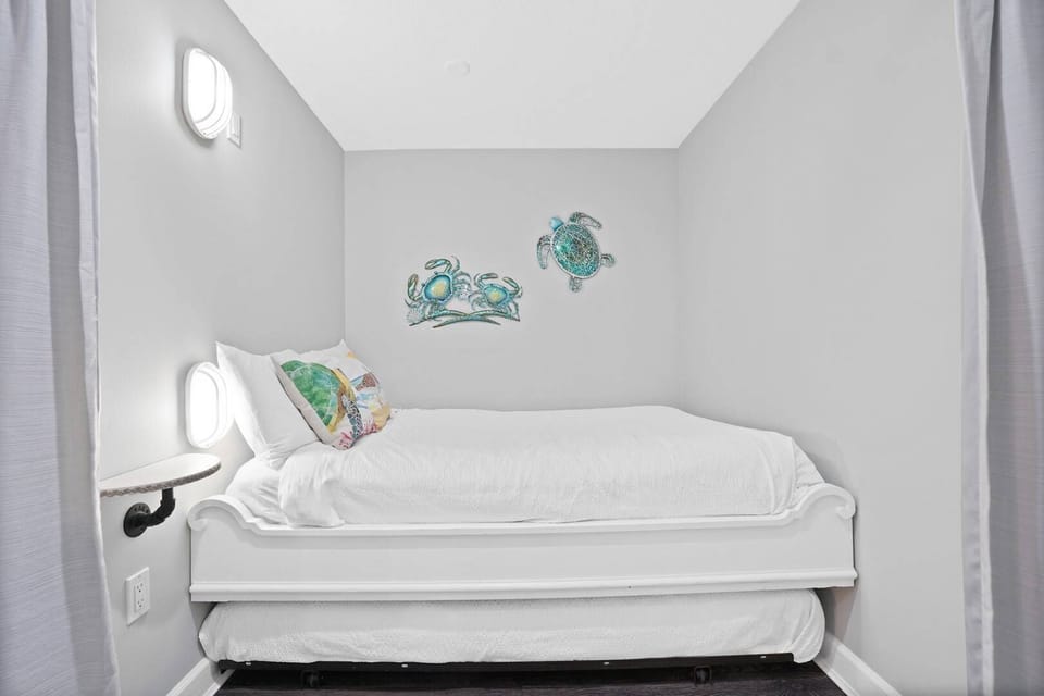 Your cozy bunk nook features nautical wall art and built-in beds with crisp linens, perfect for kids or extra guests.