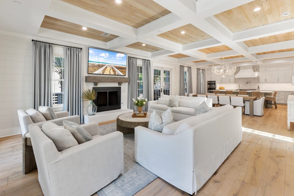 Relax in your elegant living space featuring a stunning coffered ceiling and cozy fireplace, perfect for unwinding after exploring.