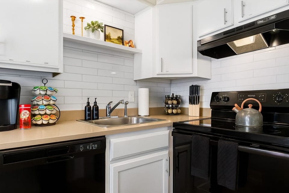 Sleek and modern kitchen, granite countertops, and a coffee station.