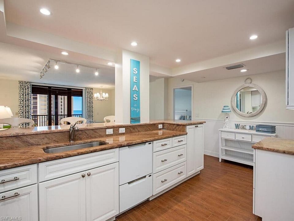 Renovated white kitchen with dining space, perfect for gathering after the beach