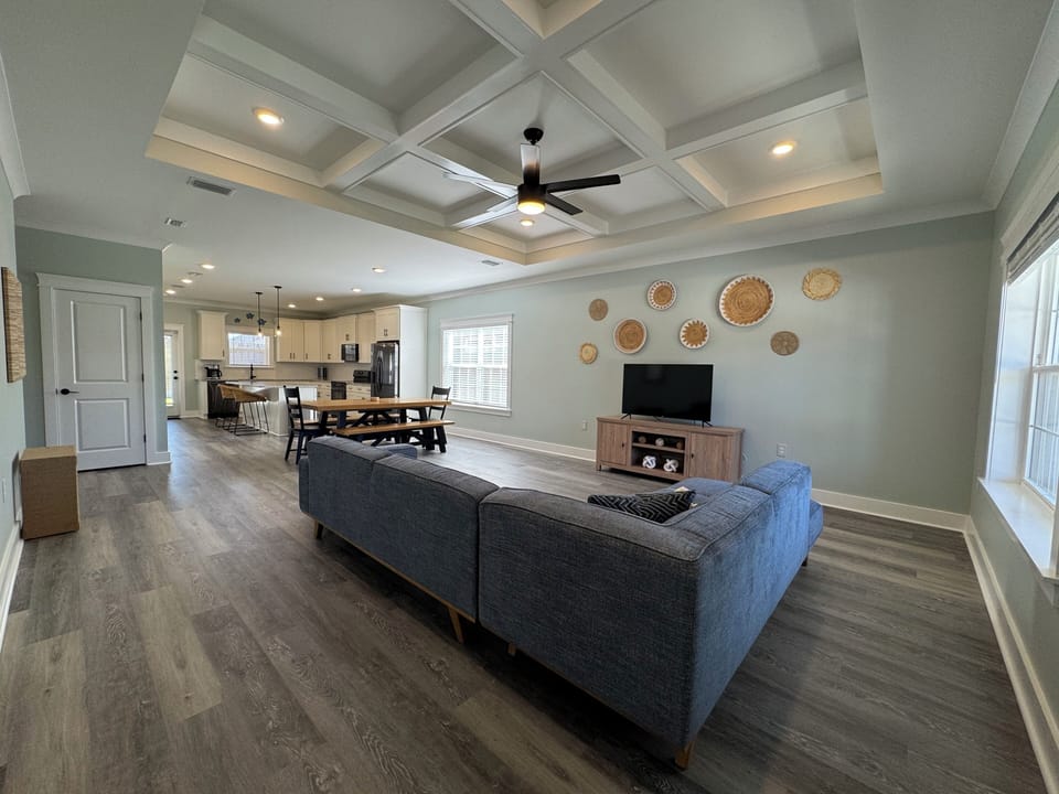 Full living room with large couch, toys/games, end tables, and smart tv.
