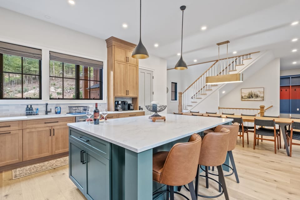 Spacious and fully equipped kitchen featuring rich wood cabinetry, a large center island with seating, and high-end appliances. With its beautiful custom cabinetry and ample natural light, this kitchen is perfect for cooking and entertaining.
