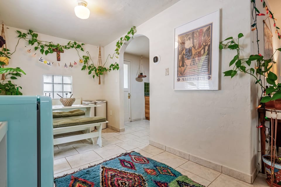 This bright and boho space blends vintage charm with vibrant textures and greenery. From the turquoise fridge to the playful textiles and cozy breakfast nook, it's the perfect mix of style and soul.