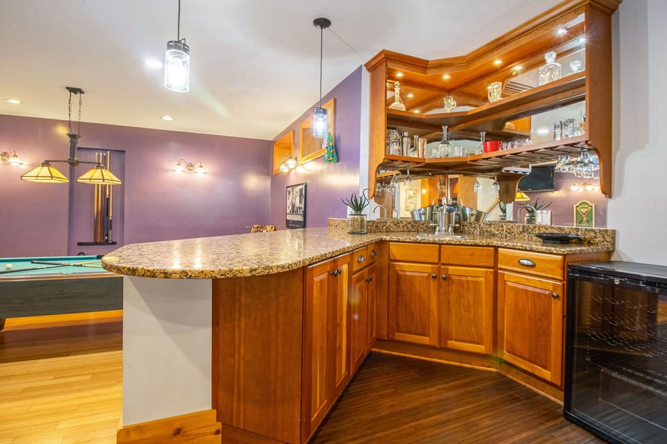 Bar area with sink, glassware, wine cooler, and bar seating