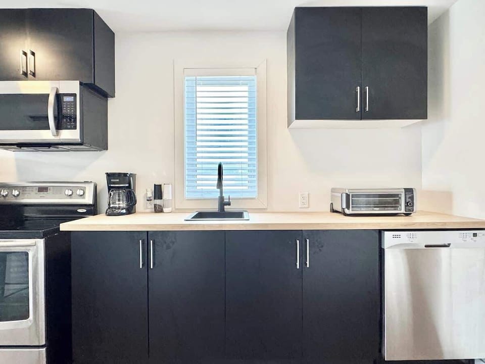 Des finitions noires élégantes et de grandes fenêtres lumineuses créent un espace stylé pour vos plaisirs culinaires!