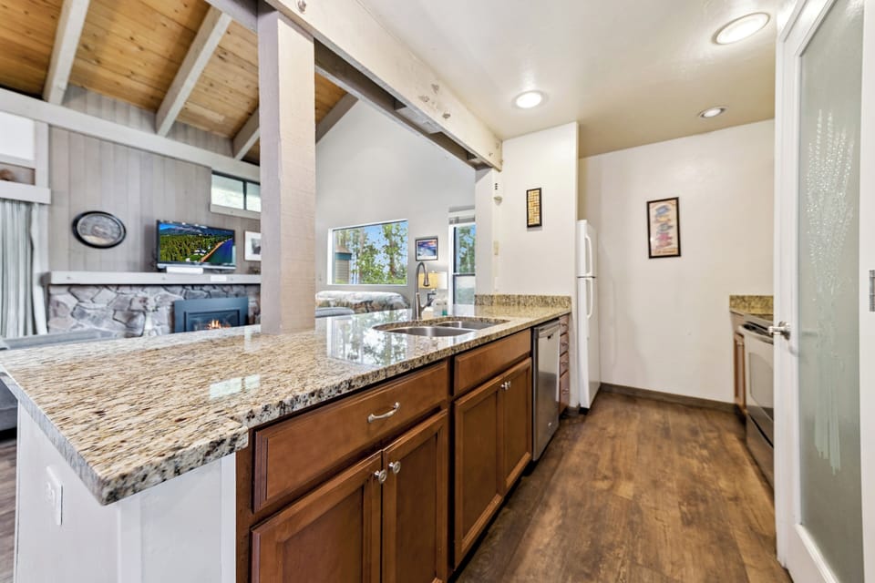 From the kitchen counter, enjoy an open view into the bright living room with vaulted ceilings.