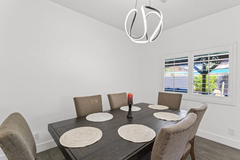 Bright dining area w/ round table & modern chandelier for relaxed shared meals.