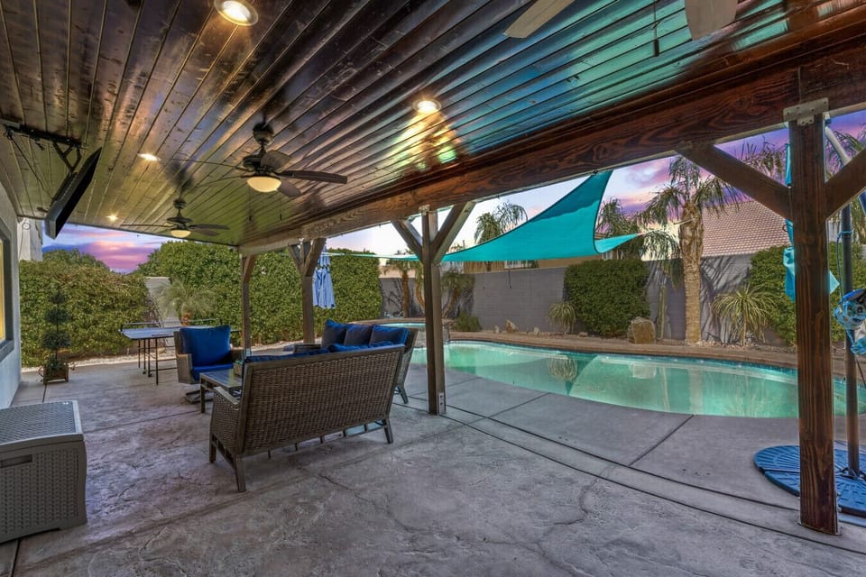 Covered patio lounge overlooking the pool, perfect for shaded evenings outdoors.