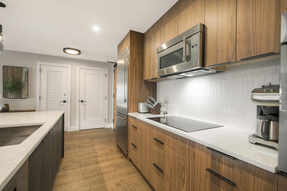Natural light floods the kitchen through wide windows — bright mornings, good coffee, and a mountain backdrop