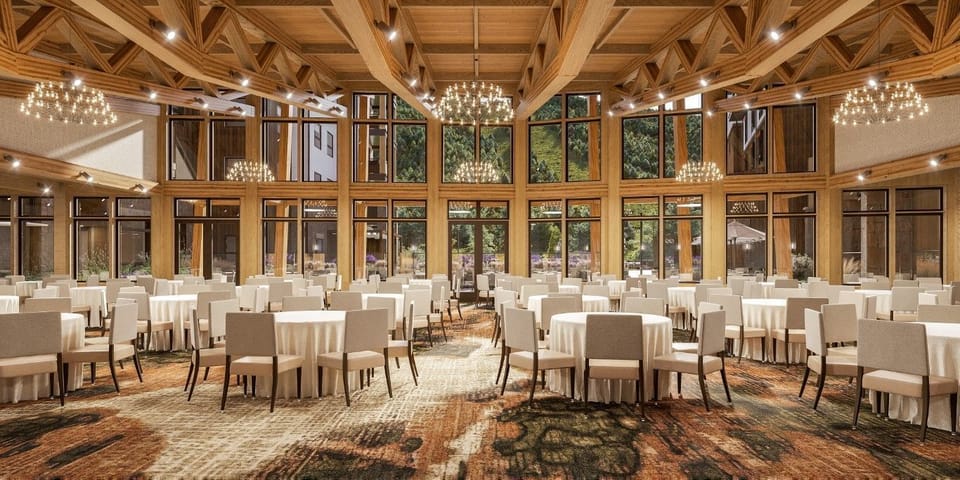 Event space filled with round tables and large windows.