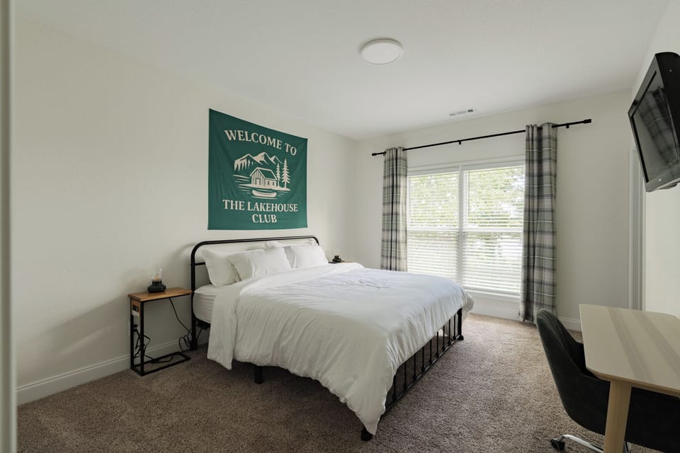 Primary bedroom with king bed, en suite bathroom, work space, tv and views