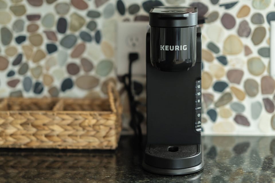 Keurig with pods, creamer packets, sugar and tea