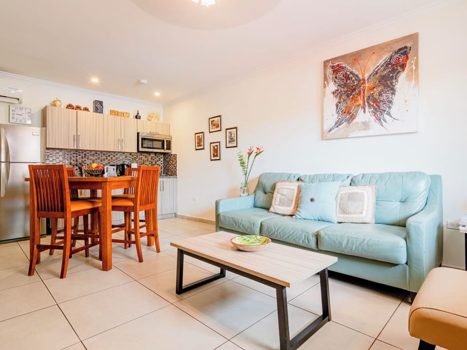 Relax in a spacious living area with cozy sofas, a large flat-screen Smart TV, and natural lighting—ideal for streaming or socializing