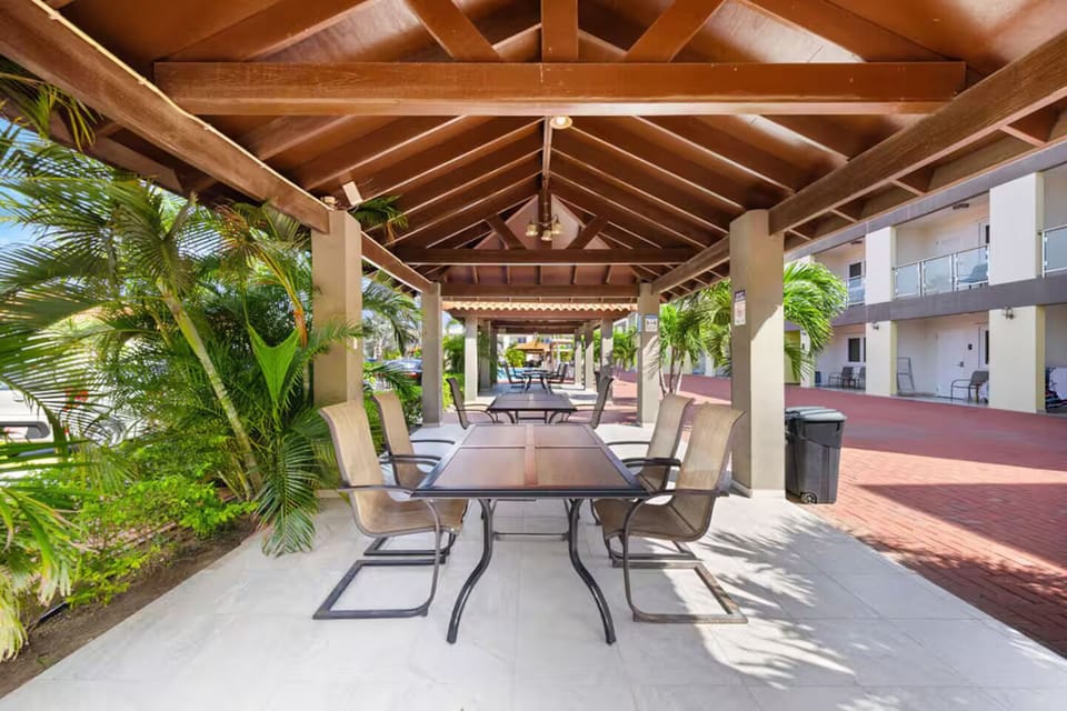Dine or gather with friends under this spacious, covered outdoor area,complete with seating, ceiling fans, and tropical vibes all around
