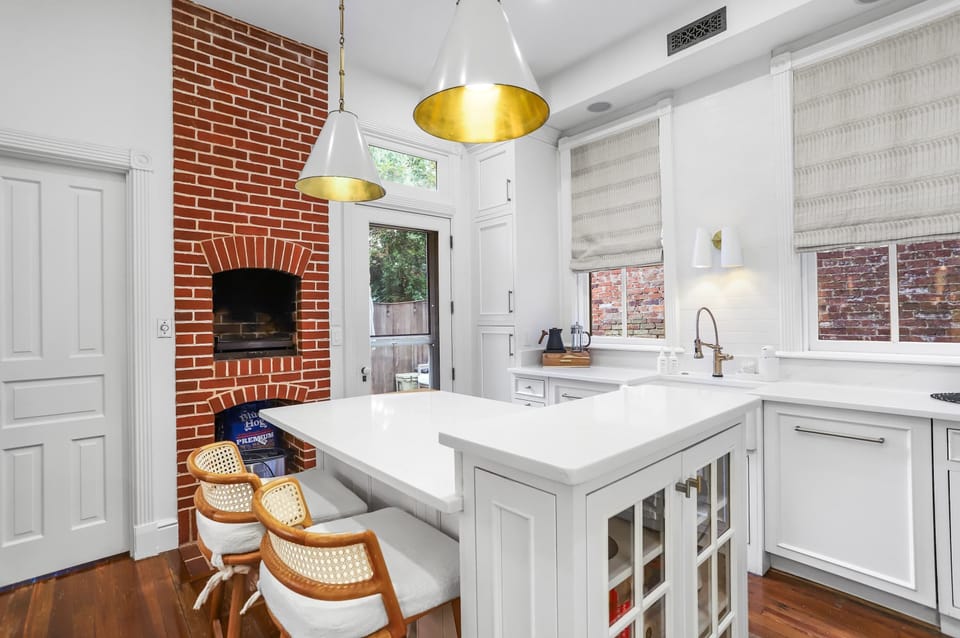 Kitchen with kitchen island, pizza oven, and view of the outside, back patio. 