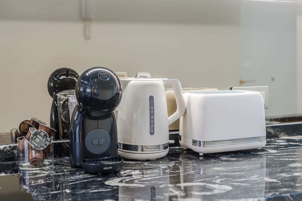 Curated Kitchen Essentials – Enjoy Mornings with a Sleek Espresso Machine, Retro Kettle and Toaster on Marble Counters
