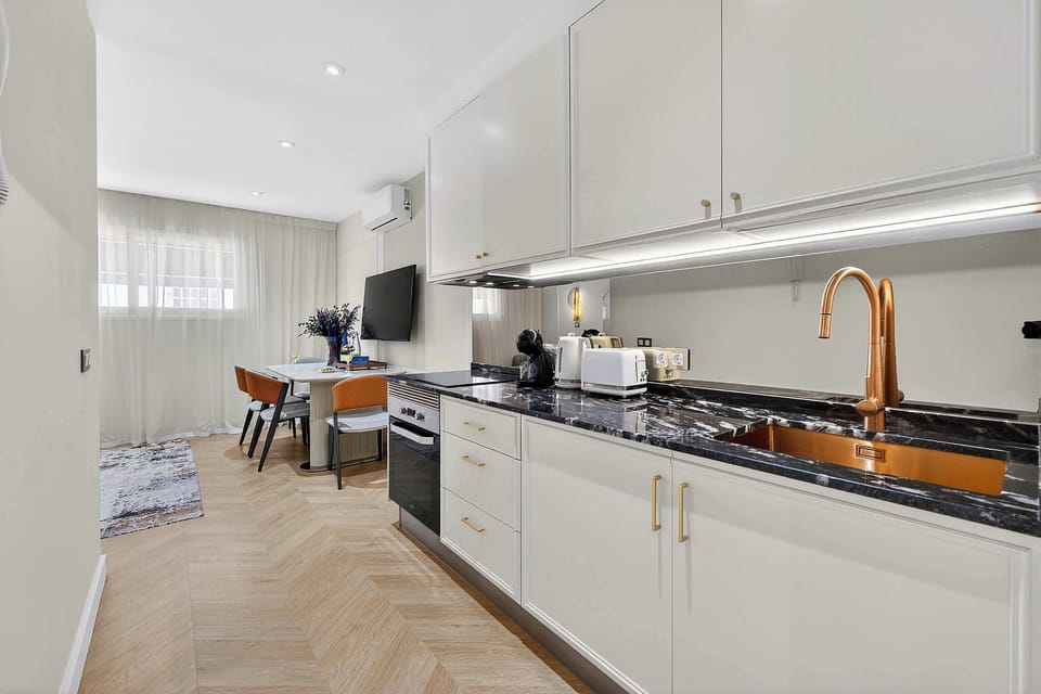 Sleek Marble Kitchen and Designer Fixtures – Cook and Dine in Style with Gold Accents and Luxe Appliances
