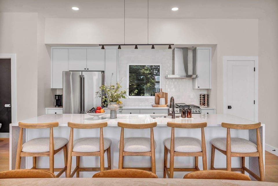 Cook, dine, and connect in this sleek modern kitchen with a spacious island, stainless steel appliances, and seating for five at the breakfast bar.