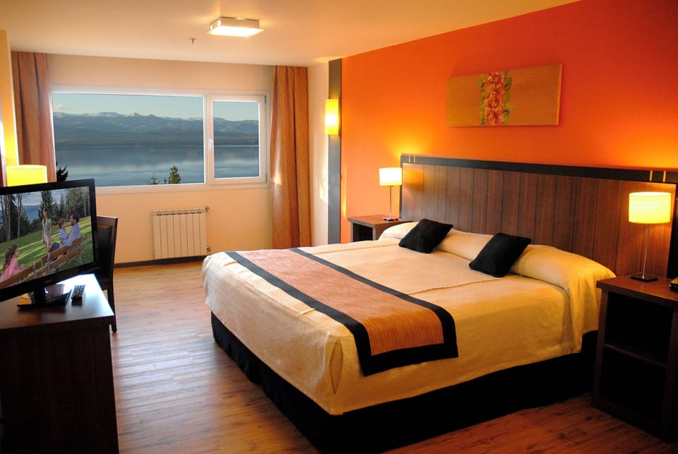 Wake up to serene lake views in a cozy bed.
