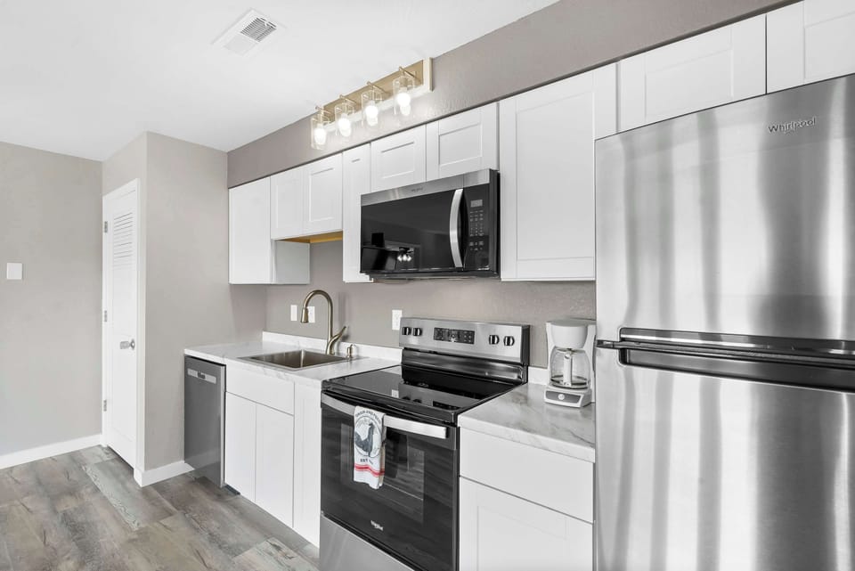 The sleek, open kitchen offers ample space & every home comfort​