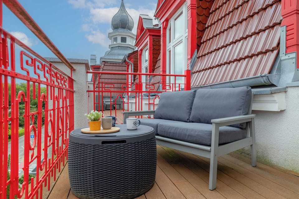 Another angle of the balcony with seating facing outward. The red railing adds vibrant contrast.