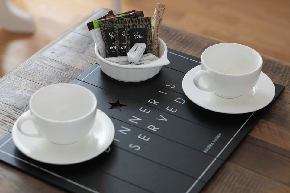 A wooden tray with two white cups and a kettle. A cozy setup for morning coffee or tea.