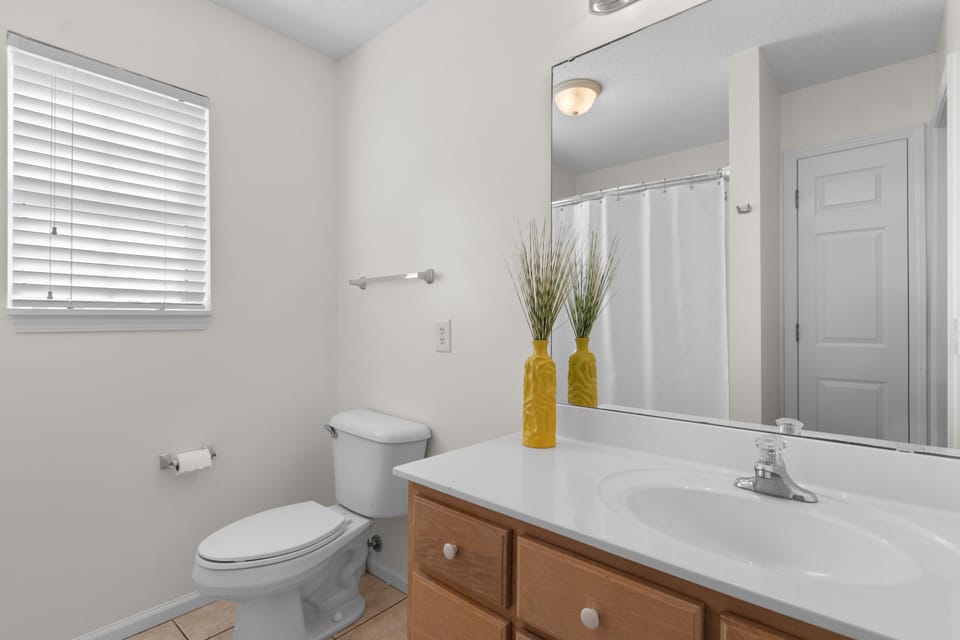 Step into your bright, clean bathroom with a spacious vanity and thoughtful touches like sunny yellow accents that make your morning routine feel refreshing.