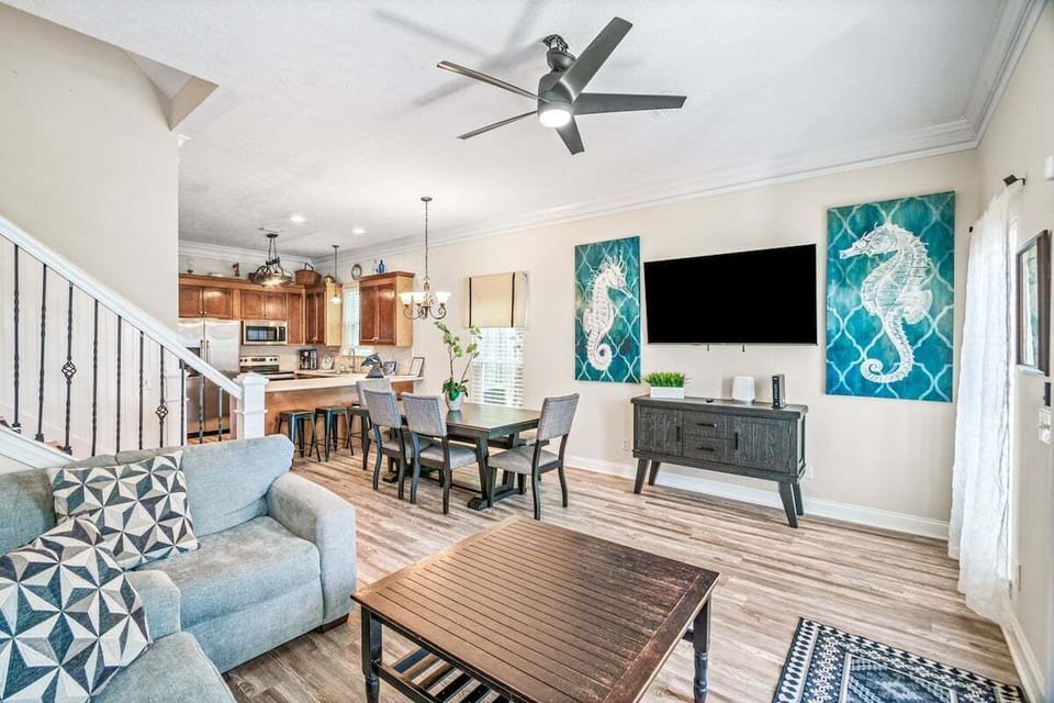 A cozy living room with a unique ceiling fan, offering easy access to the kitchen and stairs, creating a comfortable and connected space for everyone!