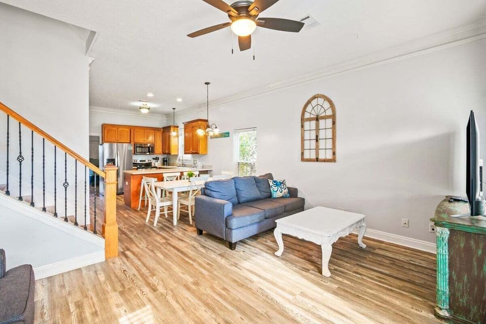 The bright and airy living room features plush seating, a smart TV, and beach-inspired décor—perfect for movie nights or morning coffee with a view.