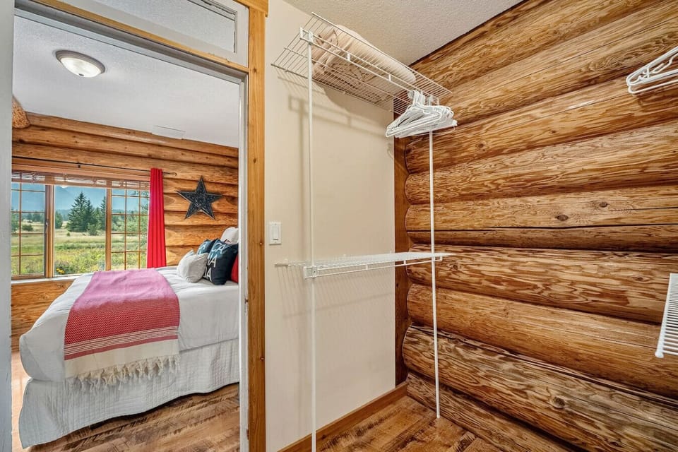 Primary bedroom, located on the main floor, with a king bed, TV, dresser, closet, portable fan, room-darkening shades. and ensuite access to the main floor full bathroom.
