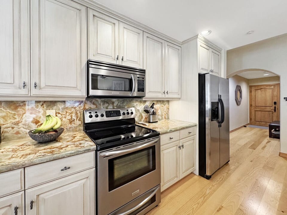 Picture yourself preparing morning coffee in this fully-equipped kitchen with gleaming stainless steel appliances. Ample counter space and complete cookware let you fuel up for the slopes or craft cozy après-ski meals