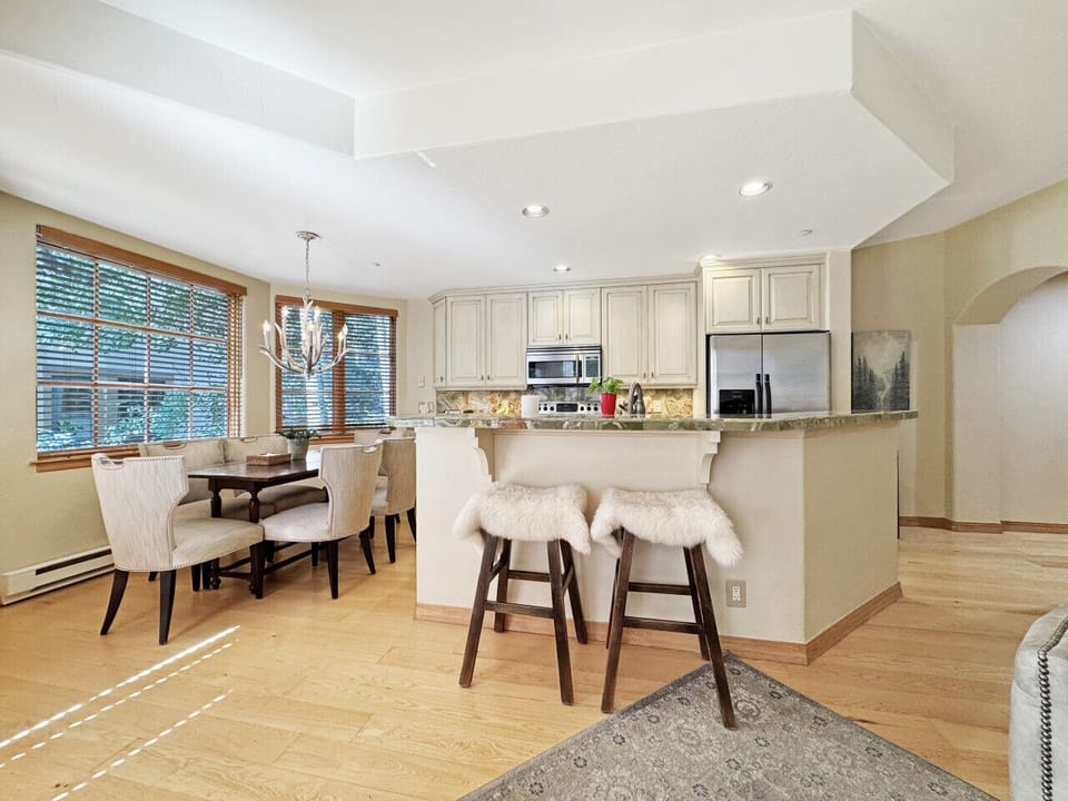 From the island`s cozy cushioned seats, take in the full kitchen and dining area bathed in natural light from village-view windows. The perfect spot to linger over coffee or unwind when you`d rather stay in than venture out