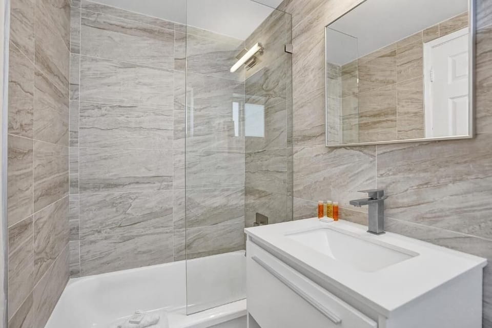 Refresh in a sleek tiled bathroom with glass-enclosed shower.