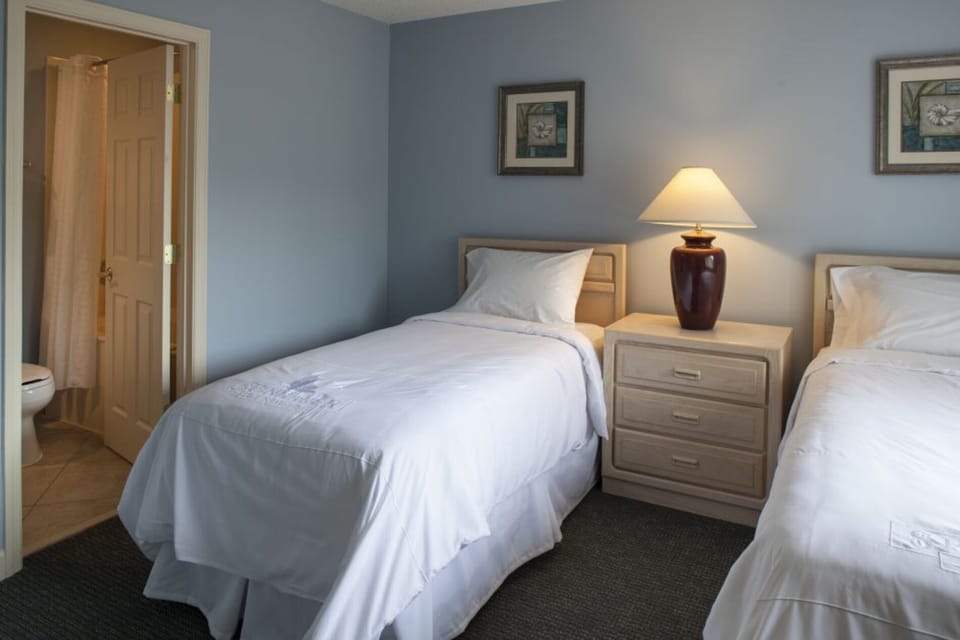 Drift off in crisp twin beds with warm bedside lighting.