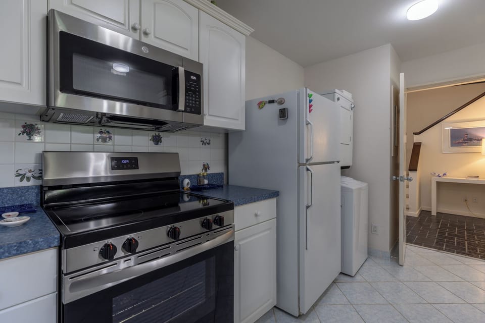 Modern kitchen with stainless steel appliances, white cabinetry, and a functional layout perfect for everyday cooking.