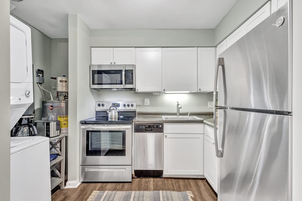 Cook up delicious meals in the modern kitchen featuring sleek finishes, top-quality appliances, plenty of counter space, and a spacious dining table.