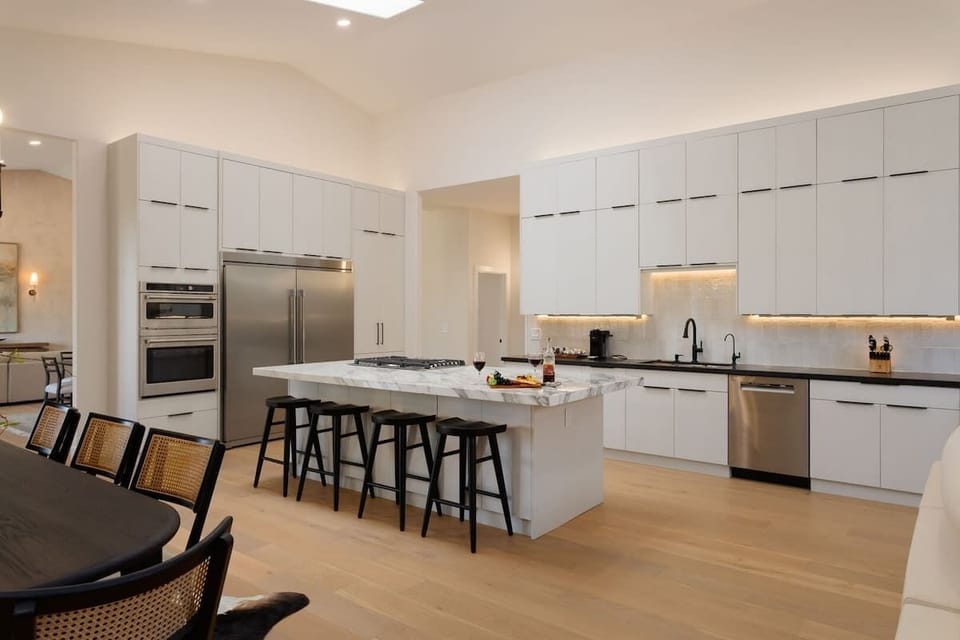 Fully equipped kitchen with stainless steal appliances, and a kitchen island with bar seating for 4 guests.