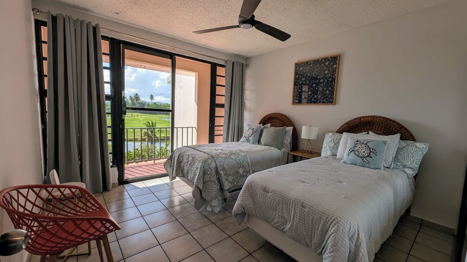 Cozy twin bedroom with patio and golf course views—ideal for peaceful stays.