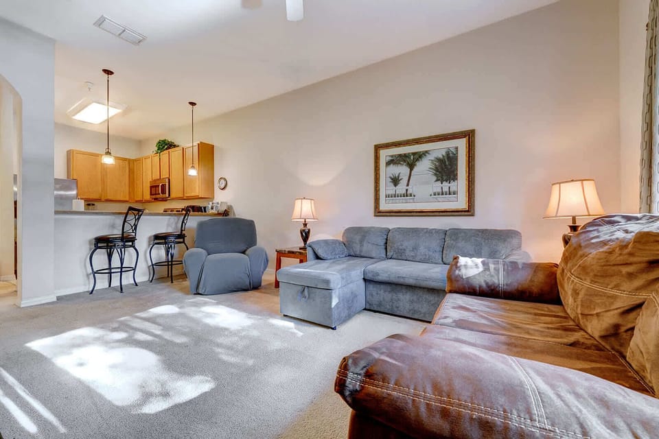 Bright living room with comfortable seating and an open kitchen with bar stools